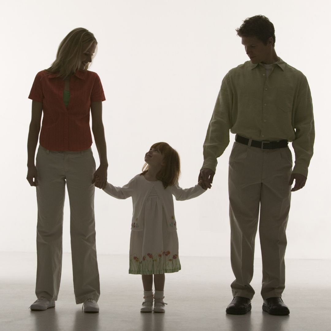 parents holding hands with child